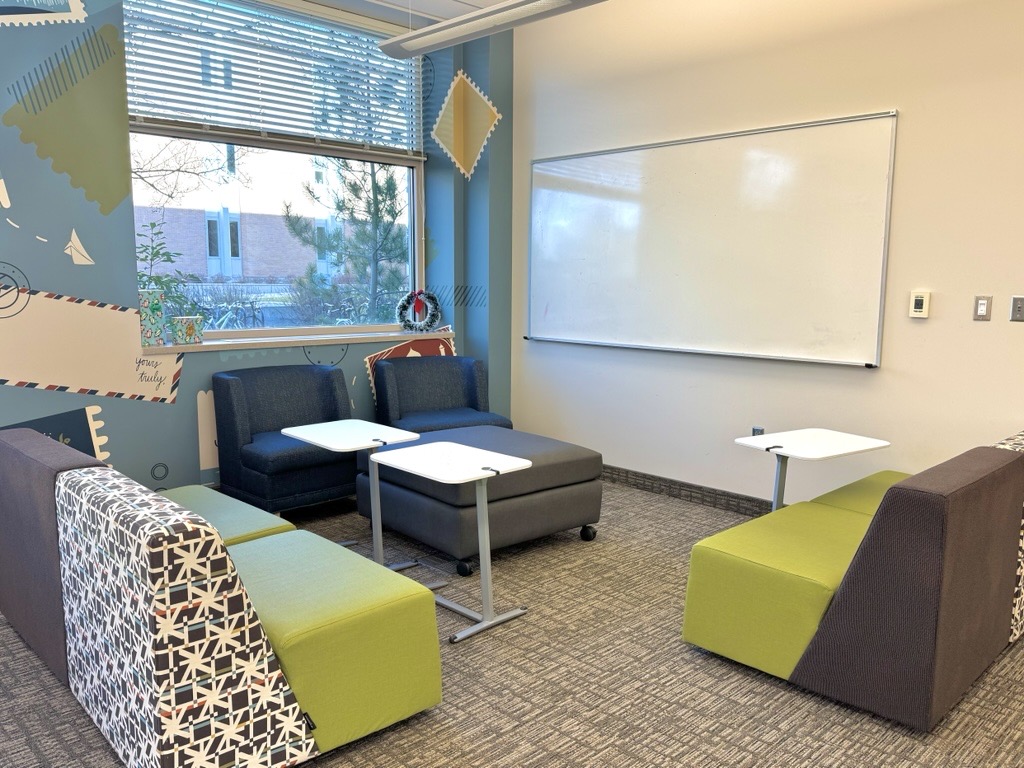 A seating area with chairs, tables, and a whiteboard